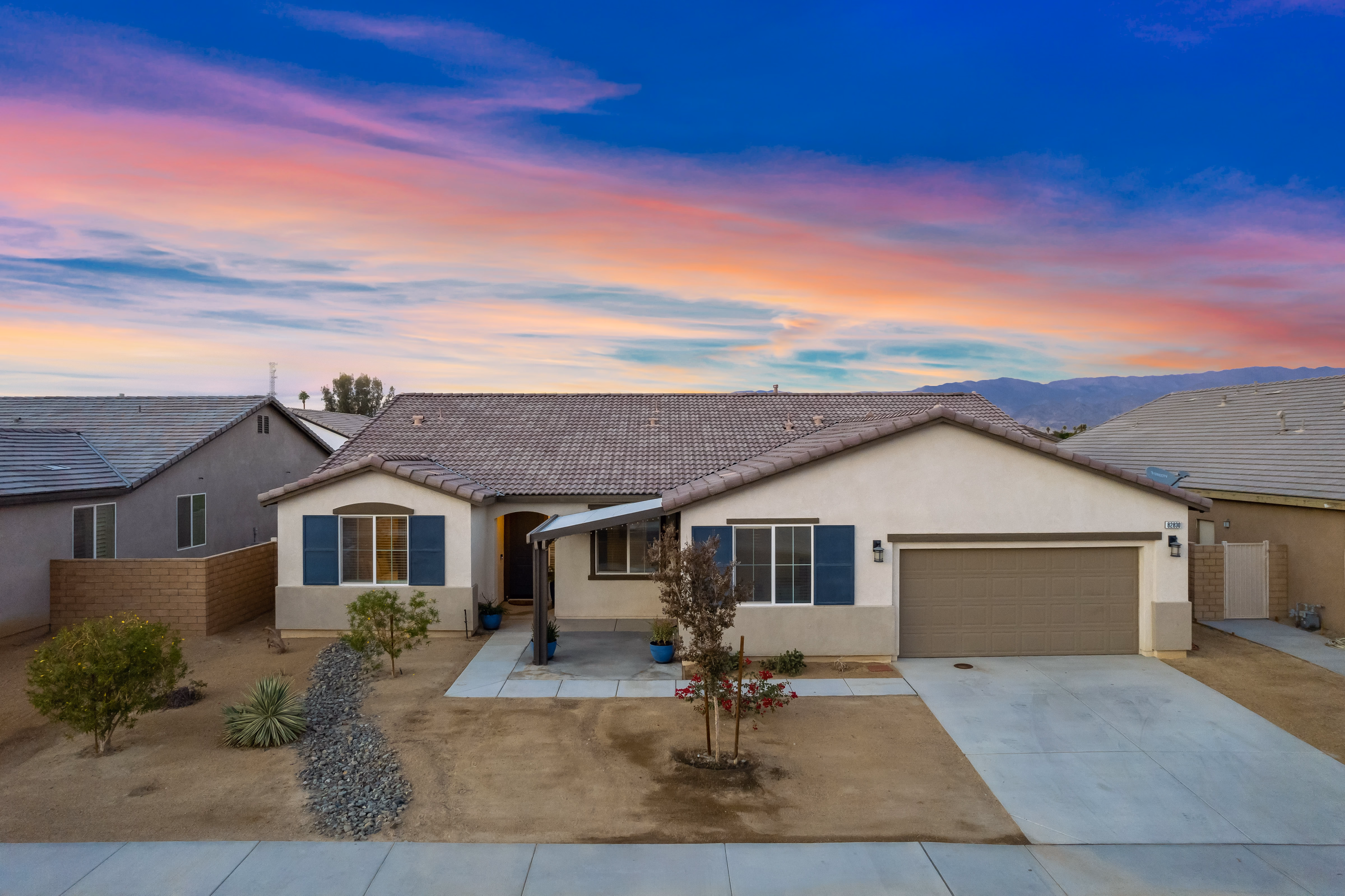 Modern single-story vacation rental property in Coachella Valley with mountain views at sunset, showcasing the type of premium short-term rental managed by SixThree8