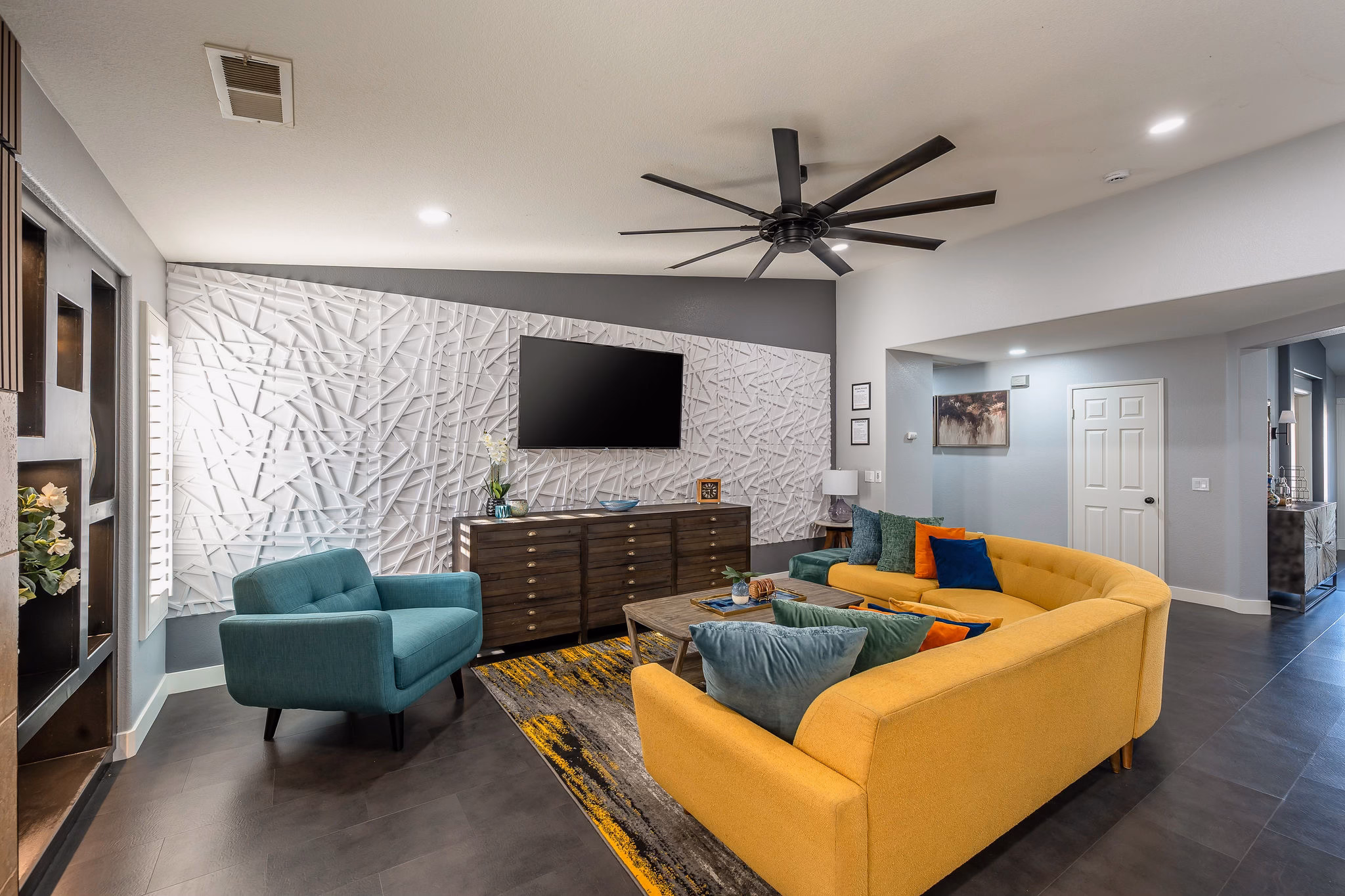 Contemporary living room with vibrant yellow sofa and teal accents - maintaining consistent luxury across every property requires detailed team coordination that ShiftFlow enables